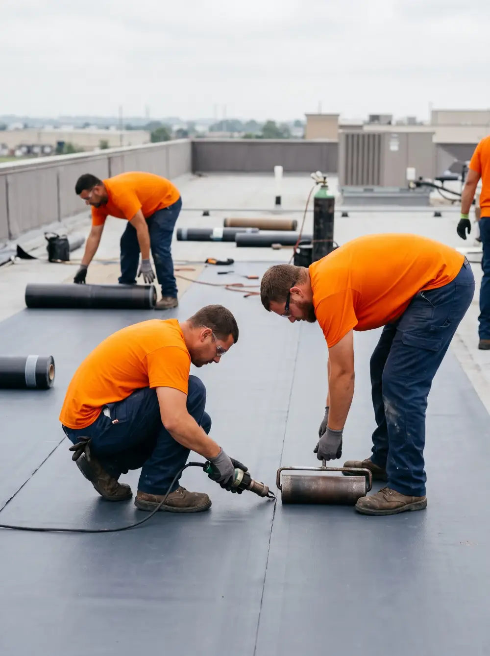 Roofer sealing seams on a flat roof membrane in Queens NY